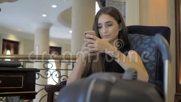 年轻女孩在酒店里看电话留言直到等她的房间视频的预览图