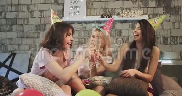 一群年轻女士在家里的卧室里举行生日聚会戴着香槟酒杯戴着生日帽视频的预览图
