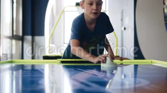 这个男孩和他父亲玩冰球沿游戏桌观看娱乐视频的预览图