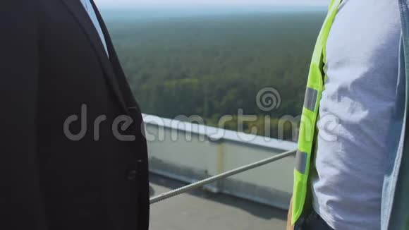 在屋顶上穿制服的商人握手合作成功视频的预览图