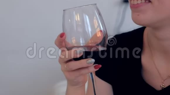 女人手里拿着一杯红酒喝葡萄酒视频的预览图