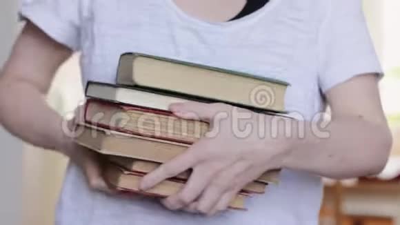 女娜手挣扎着背着一堆书近距离的带着浅浅的景深视频的预览图