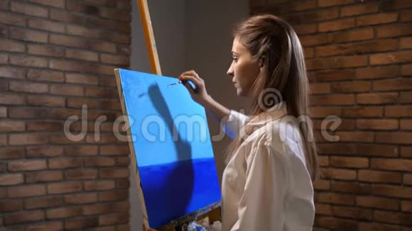 新手艺术家描绘风景调色板刀女孩做一个美丽的蓝天4K慢慢视频的预览图
