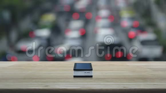 现代智能手机屏幕上的麦克风平板图标在木桌上模糊的高峰时间与城市的汽车和道路Busine视频的预览图