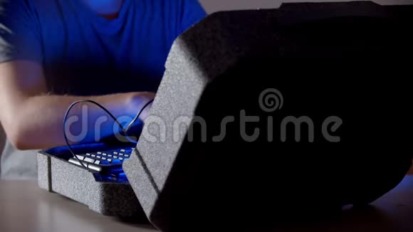 一个男人正用蓝光在电脑上打字视频的预览图
