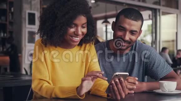 坐在咖啡馆里的女人和她的朋友分享短信视频的预览图