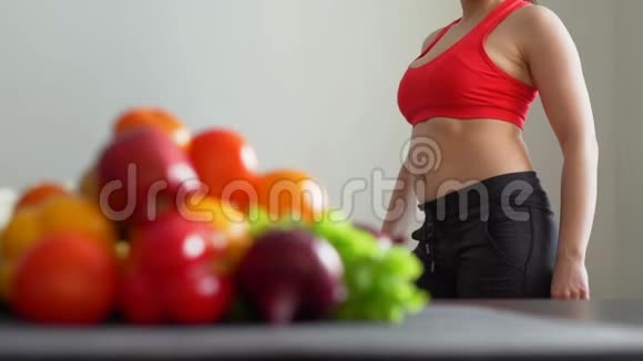 女人在水果和蔬菜附近测量她的腰围视频的预览图