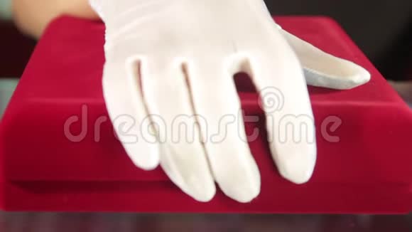 手提白色手套打开红色天鹅绒珠宝盒与银坠与洋红diamondJewelleryJewelry店员视频的预览图