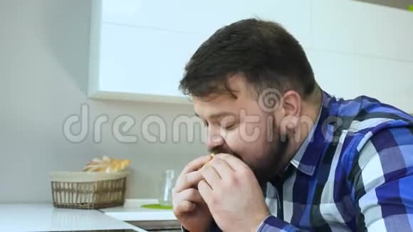 一个超重的人吃他的汉堡包喝碳酸软饮料他喜欢自制的食物不健康视频的预览图
