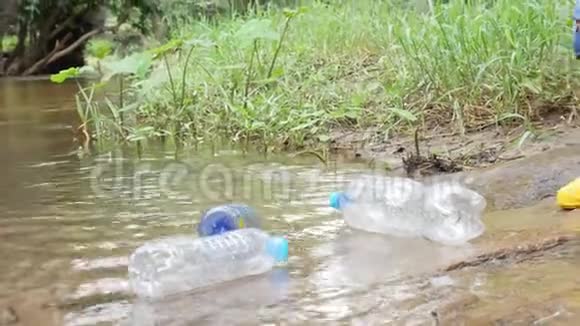亚洲小孩正在捡起漂浮在河岸上的塑料垃圾环境保护概念视频的预览图