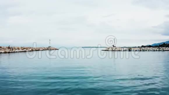 无人机飞过绿松石的海水离开港口视频的预览图