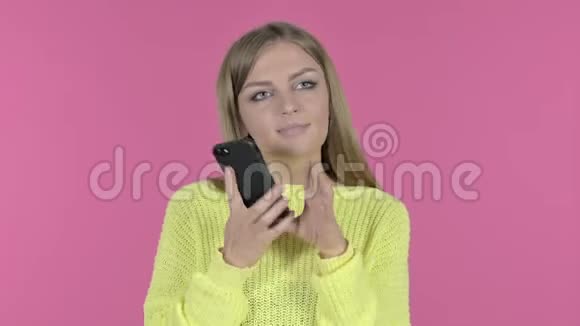电话交谈的快乐少女粉红背景视频的预览图