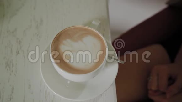 年轻女子拿起一杯咖啡视频的预览图