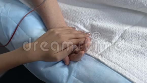 在医院病房里女人从昏迷病人手中夺走悲伤视频的预览图