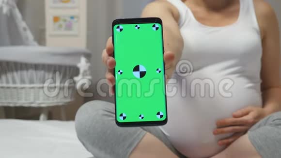 孕妇手里拿着一部黑色智能手机视频的预览图