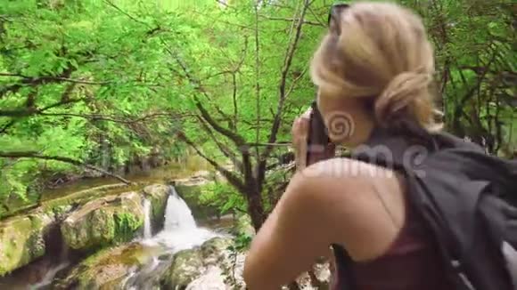 马尔特维利峡谷的绿色自然金发碧眼的女孩站在边上专业摄影师视频的预览图