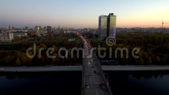 鸟瞰桥上活跃的交通傍晚横跨大河车上可见灯光在里面视频的预览图