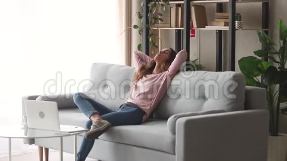 放松的女孩坐在沙发上享受无压力的一天视频的预览图