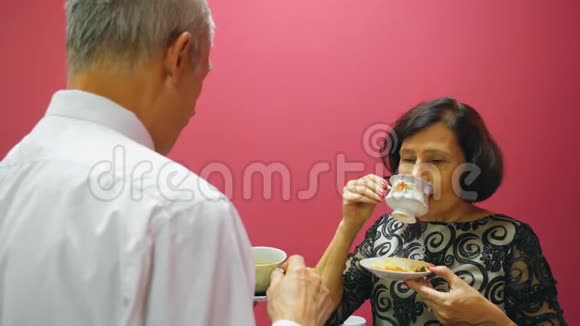 老两口喝着茶和饼干聊天老年人的生活方式视频的预览图