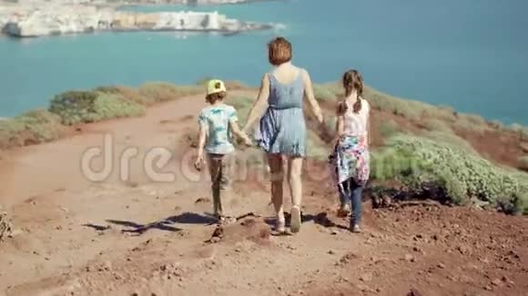 后景的母亲和孩子走在路上牵着手视频的预览图