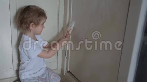 一个可爱活泼的小女孩用刷子和油漆粉刷了门染了手指视频的预览图