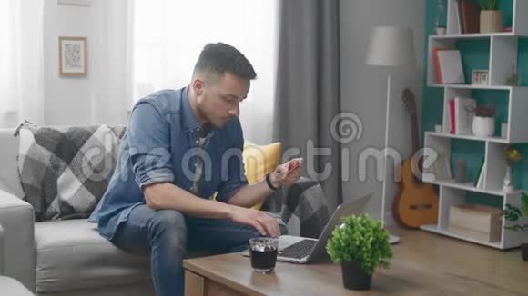 男人在家他持有信用卡和类型它号码进入他的笔记本电脑视频的预览图