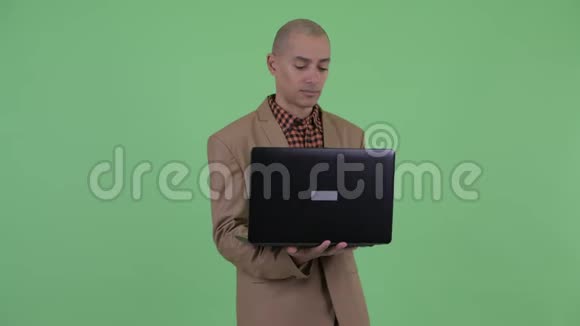 严重的秃头多民族商人使用笔记本电脑思考视频的预览图