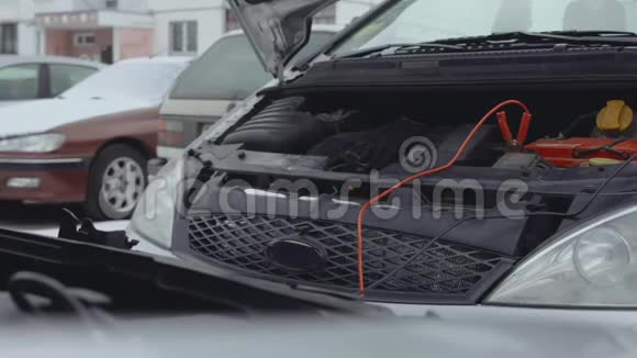 放电汽车电池是从汽车电池充电使用跳线钳电缆连接到后端子胡德视频的预览图