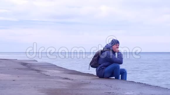 冬日的人坐在古老的海滨看海景视频的预览图
