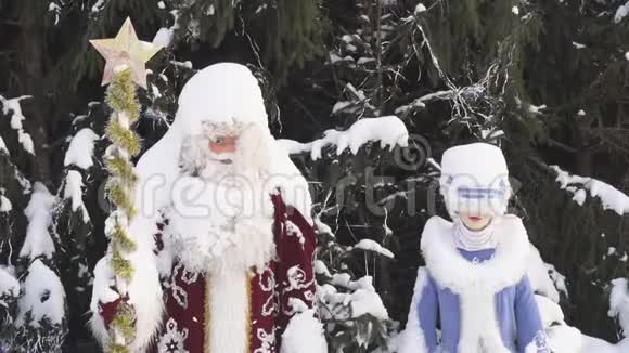 圣诞老人和雪少女靠近圣诞树特写视频的预览图