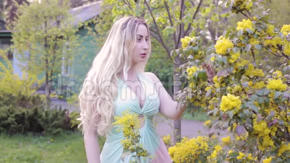 女人嗅着一棵开花的树视频的预览图