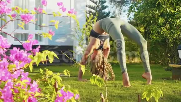 年轻女子正在她家后院做桥牌瑜伽姿势视频的预览图
