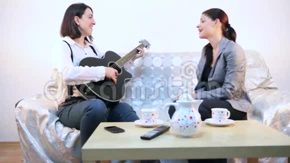 女人用吉他和声音演奏歌曲视频的预览图