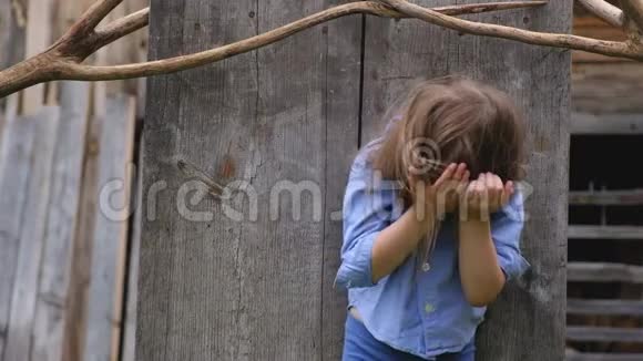 穿着时髦衣服的小可爱女孩在木制屏幕的背景下摆姿势视频的预览图
