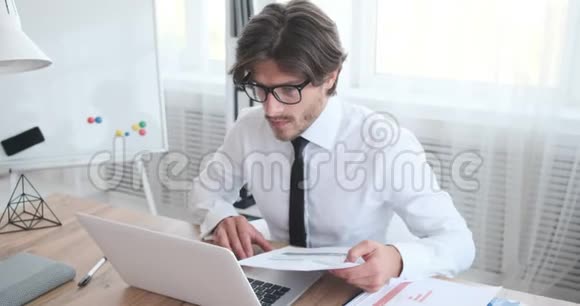 商人在办公室使用笔记本电脑时检查文件视频的预览图