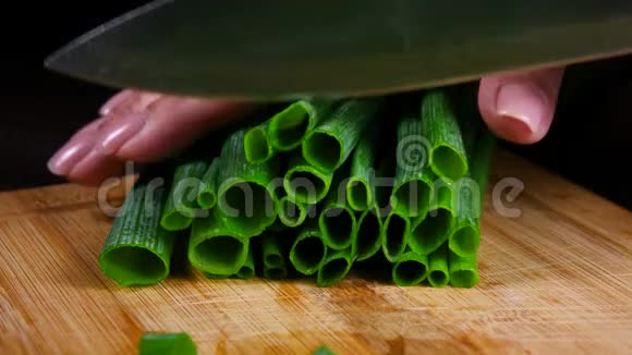 在木切板上切绿色新鲜洋葱快关门视频的预览图