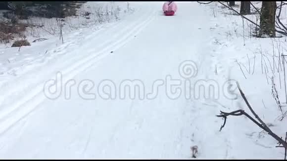 年轻人骑雪橇下山滑雪坡冬季运动和乐趣成人和儿童玩具寒假视频的预览图