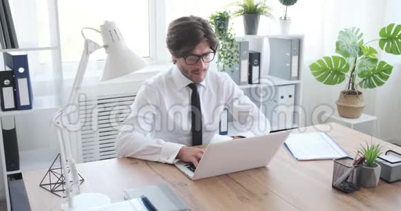 商人在办公室使用笔记本电脑时检查文件视频的预览图