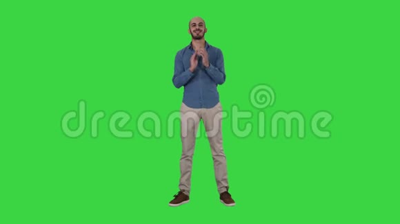 站着的阿拉伯年轻人在绿色屏幕上微笑着拍了拍他的手铬钥匙视频的预览图