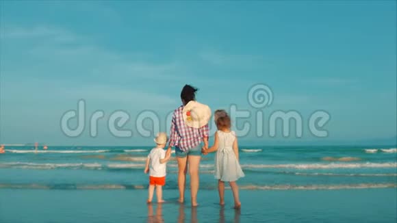 幸福的母亲和女儿和儿子在日落时在海滩上玩和玩动作缓慢幸福家庭视频的预览图