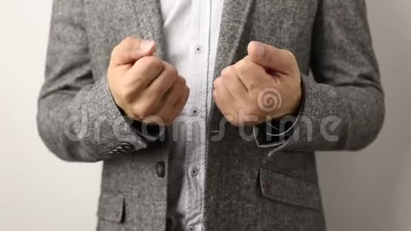 一个穿着灰色夹克衫白色背景上有斑点衬衫的白种人慢慢地数着手指直到十个视频的预览图