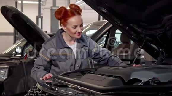 漂亮的女汽车修理工用敞篷汽车检查视频的预览图