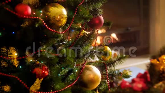 特写4k镜头美丽的彩色发光灯花环和珠子在圣诞树上燃烧的火视频的预览图