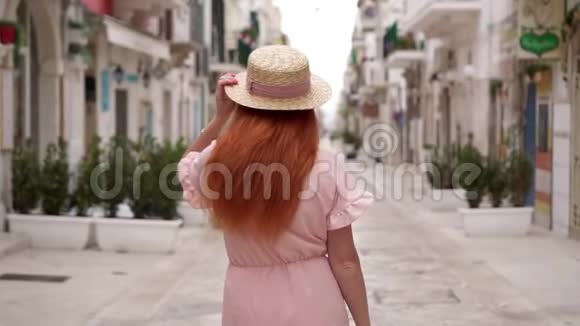 快乐的年轻女性游客走在欧洲老城区的街道上微笑着看着摄像机视频的预览图