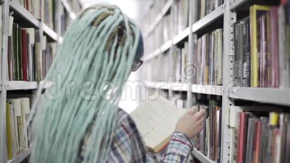 希普斯特女子站在书架旁读大学图书馆的书视频的预览图