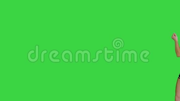 年轻快乐的运动女性跳舞和听音乐耳机在绿色屏幕Chroma键视频的预览图