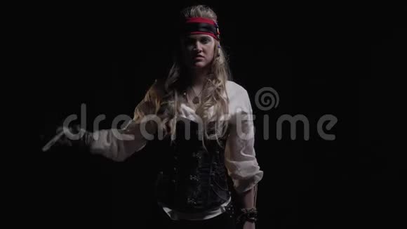 穿着海盗服装的金发女人正拿着剑站在黑暗中4K视频的预览图