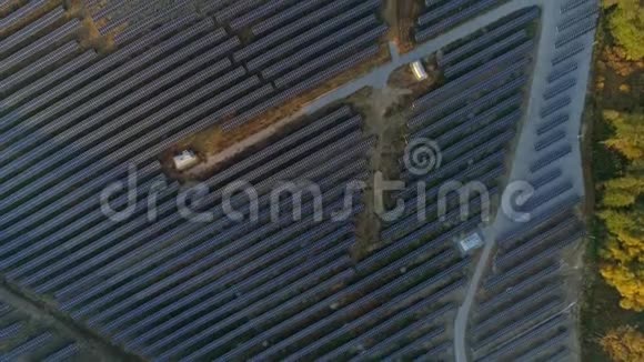 空中无人机镜头在秋天的日落季节飞越太阳能电池板农场自上而下的视野视频的预览图