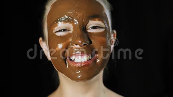 可爱的女孩微笑脸上涂满巧克力视频的预览图