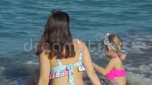 母亲和女儿享受海水的温暖视频的预览图